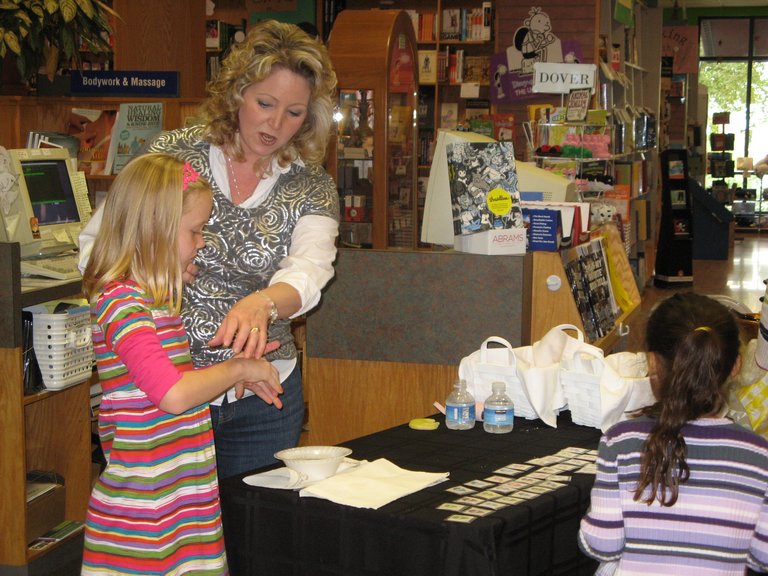 Here, Carmen Oliver and daughter work the press-on alien-head tattoo table. Here, Carmen Oliver and daughter work the press-on alien-head tattoo table.