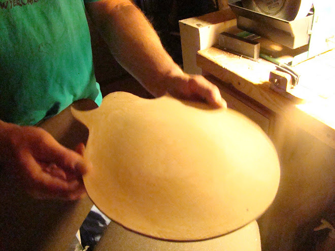 SHADOWS FOLLOW THE CURVATURE OF THE WOOD ON THIS NEWLY CARVED MANDOLIN TOP