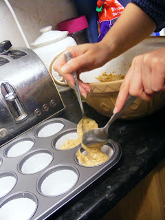 Adding the batter to the cupcake liners.