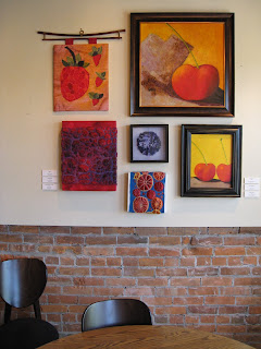 A brick cafe displaying the artwork 'The Fruits of Summer Show'