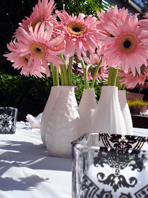 Centerpieces were clusters of pink gerbera daisies in white vases surrounded