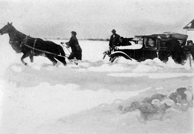 Horses pulling car stuck in snow