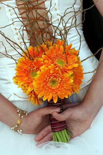 Gerbera bouquet with twigs Vibrant orange daisy wedding bouquet with long