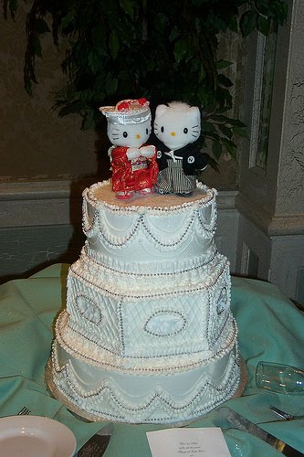 Traditional white three tier wedding cake with a surprising Hello Kitty cake