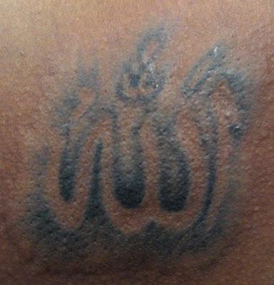 Tattoo: Arabic script, meaning "God" Location: Left side back shoulder