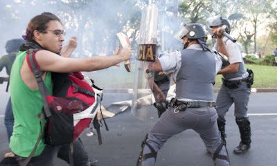 Guerrilheiro armado com um caderno recheado de explosivo plástico se prepara para atirá-la nos PMs.