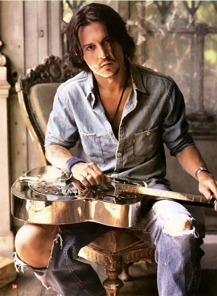 Johnny Depp sitting with guitar