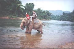 a tourist taking an "elephant Ride" at the "Elephant Village" in Kanchanaburi.