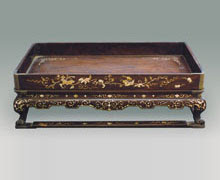Tray wood inlaid with mollusk shell.