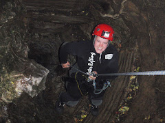 Erin abseiling (notice the small black hole to the left of Erin, that's the cave entrance.