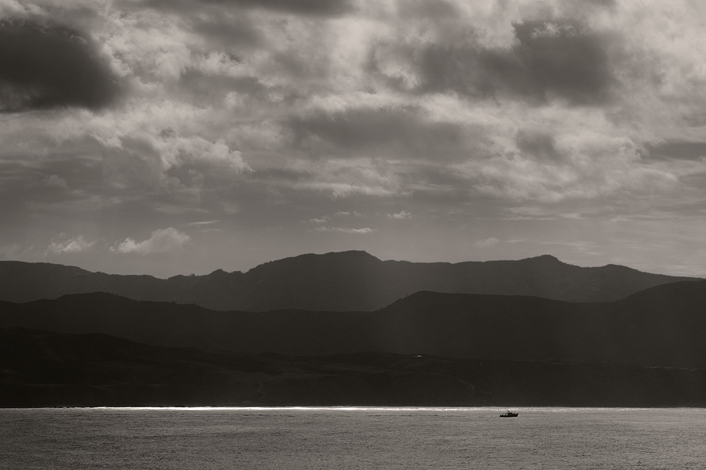 Sailing past Pencarrow Head, the Rimutaka Range beyond.