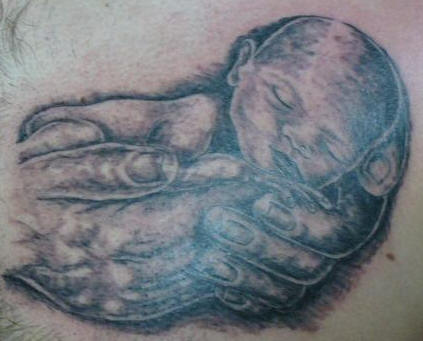 Tiny sleeping baby tattoo.