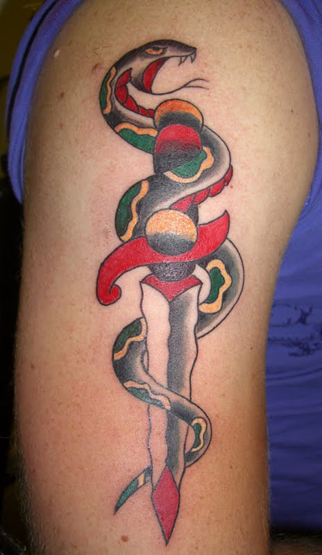 Coiled snake and dagger tattoo on arm
