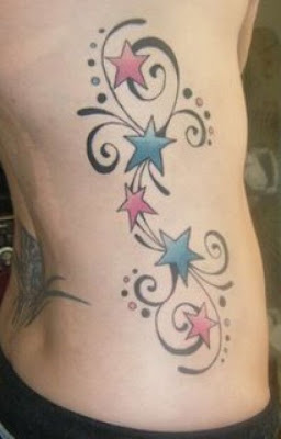 Colorful stars rib tattoo.