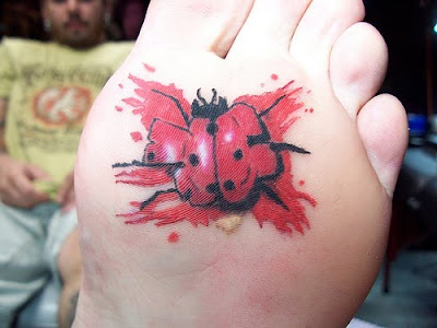 Ladybug tattoo on bottom of foot.