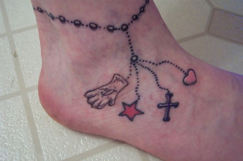 Ankle bracelet tattoo with heart cross star and glove.