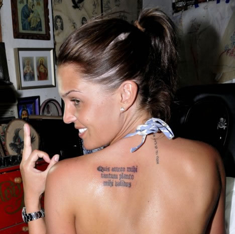 flower tattoos on back of shoulder. Ms. Lloyd also has a Latin phrase on her back left shoulder which reads 