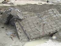 舊建物廢棄的石塊任意堆埋在沙灘上，  被颱風大雨沖刷過後露出的殘骸-1 (照片由台東環境保護聯盟提供)