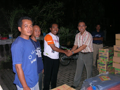 Mr. Ketut (right), on behalf of DEJAVATO Indonesia, gives the relief goods to Mr. Widodo as the coordinator of Kemudo village aid workers - Dejavato Indonesia