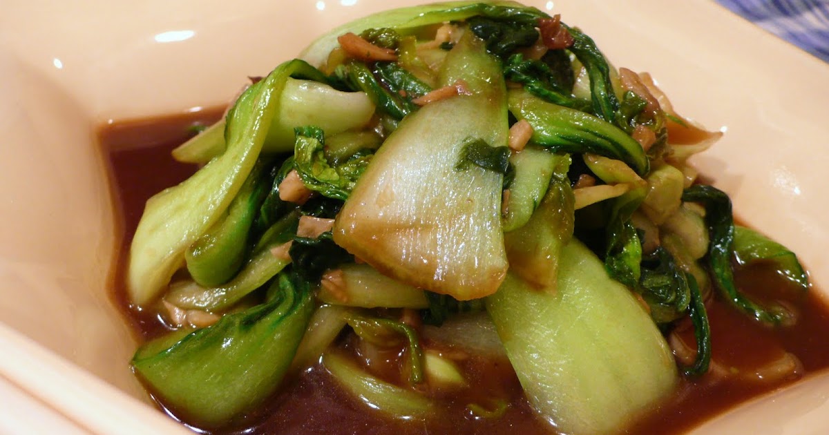 a dish with two sticks Fried Baby Bok Choy with Oyster Sauce 青梗菜のカキ油炒め
