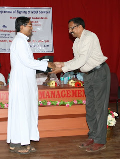 Fr Valerian D'Souza exchanging the MOU with Mr K. Jayraj Pai