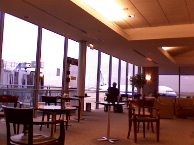 a man sitting at a table in a room with large windows