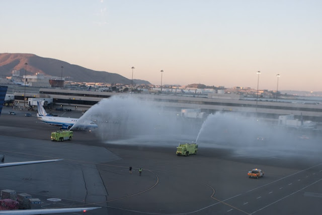 fire trucks spraying water on an airport