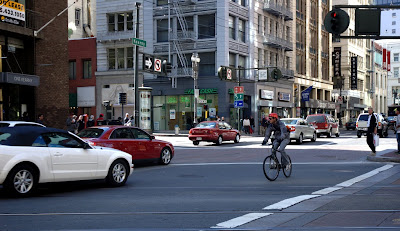 Image of red light running cars impeding bicyclist with the right of way