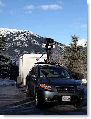 Ein Foto zeigt ein Auto mit einer Kamera auf dem Dach und einem Anhänger.