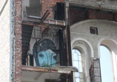 A blue spray-painted face on one of the interior walls