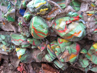 Multi-colored green, red, yellow and white glass chunks embedded into the red rocks