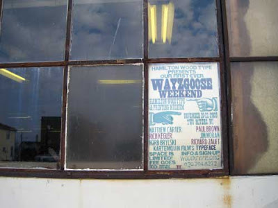 Woodtype printed sign for the Wayzgoose in the window of the museum