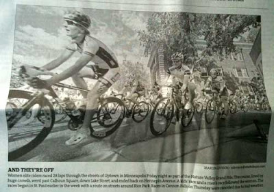 Black and white newspaper clipping of a bunch of serious-looking bicyclists in a race