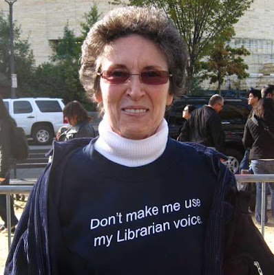 Dark t-shirt with white letters reading Don't make me use my librarian voice