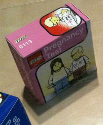 Male and female figures with pregnancy test. The box is pink