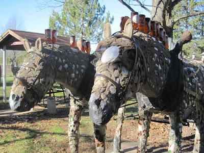 Two horses with brown beer bottles used to make their manes