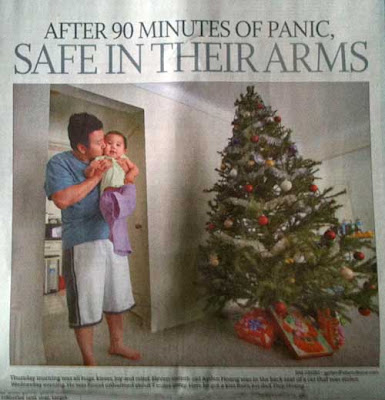 Star Tribune photo of a young Asian man hugging and kissing a baby by a Christmas tree