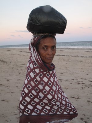 Kiwaiyu Woman with bag of Flip flops on her head