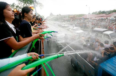 Festival goers spray water on passer-bys in vehicles celebrating Thingyan, Myanmar's new year water festival, in central Yangon