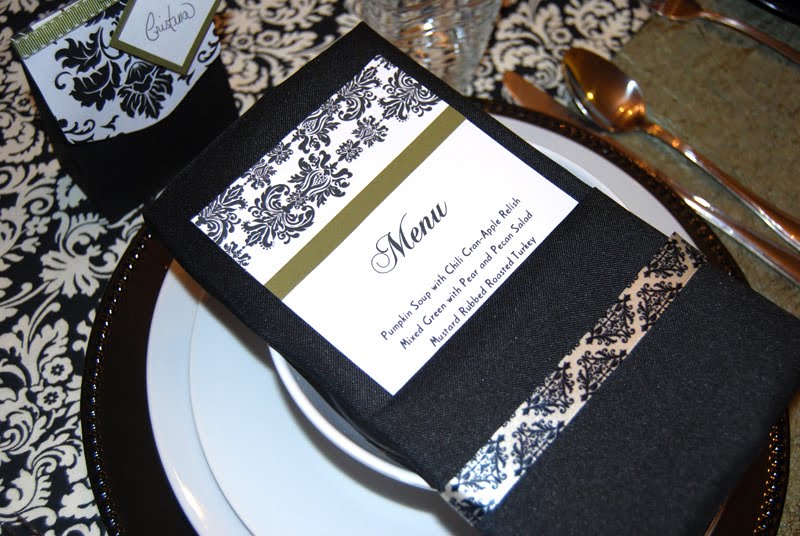 Menu card tucked into a pocket folded black napkin decorated with damask 