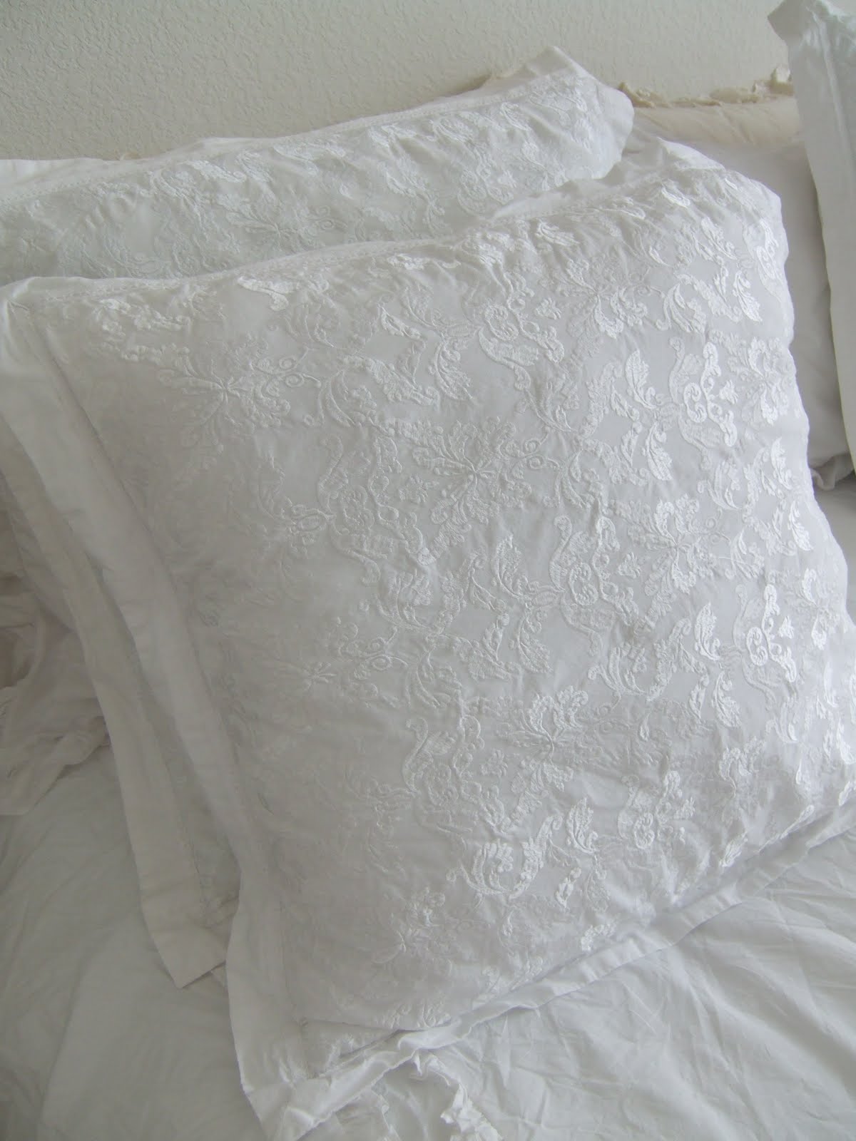 White embroidered pillows add