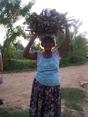 old lady carrying wood to cook with