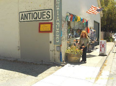 Unknown woman in front of antique shop...