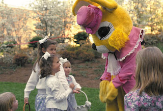 Children smiling and playing at with A funny giant bunny in the garden while children's Easter egg hunt sexy photo