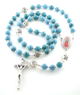 The holy rosary with sky blue color beads and silver Jesus on cross in center photo