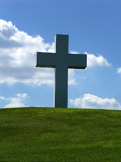 Jesus Christ's Cross statue on the hill of grass with sky Christian nature religious background photo