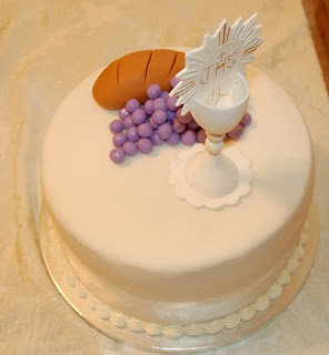 White cake with grape, chalice, and bread toppers