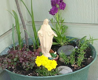 Miniature Mary statue in pot with plants
