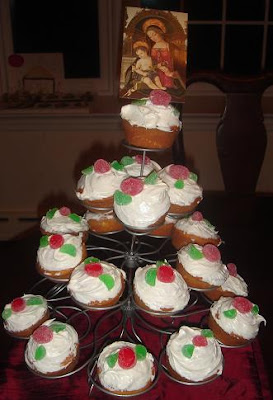 Cupcake tower full of cupcakes with image of Mary and Baby Jesus on top