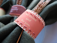 Pink paper napkin rings reading "we thank God for you"